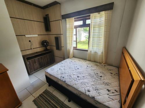 a small bed in a room with a window at Residencial Silveira in Itajaí