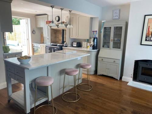 a kitchen with a large island with bar stools at Poets Place - lovely 4 bedroom townhouse with garden in Brighton & Hove