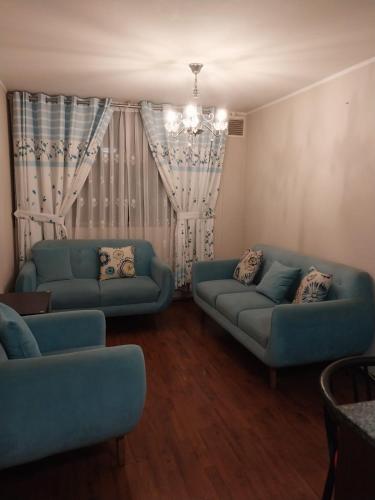 a living room with two blue couches and a window at departamento de 1 dormitorio in Lima