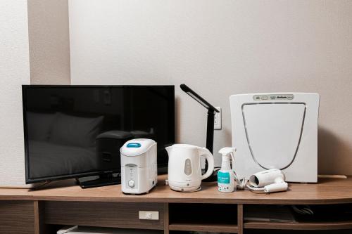 a desk with a tv and some items on it at Smile Hotel Hakataekimae in Fukuoka