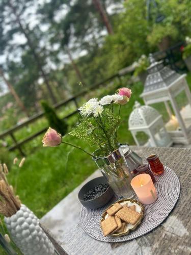 - une table avec un vase, des fleurs, des biscuits et une bougie dans l'établissement Uteplats, à Göteborg