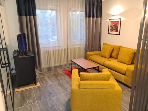 sala de estar con sofá amarillo y TV en Runaway Hill, en Bežanija