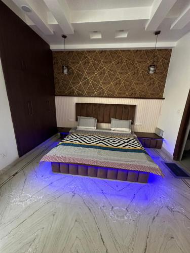 a bedroom with a bed with purple lights on the floor at The Grey House! in Noida