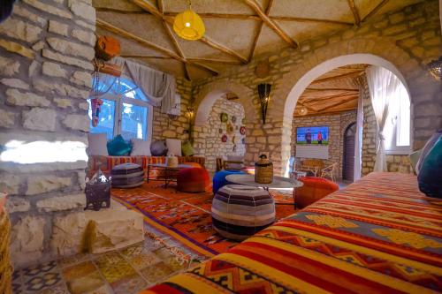 een kamer met een stenen muur en een kamer met bedden bij Villa jamal in Essaouira