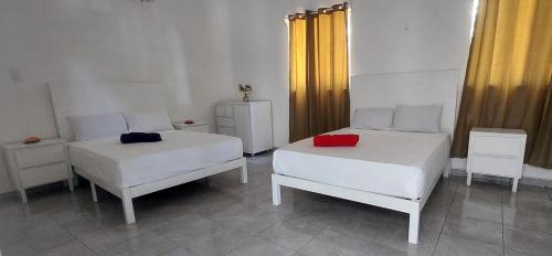a room with two beds and two chairs at Casa frida bacalar in Bacalar