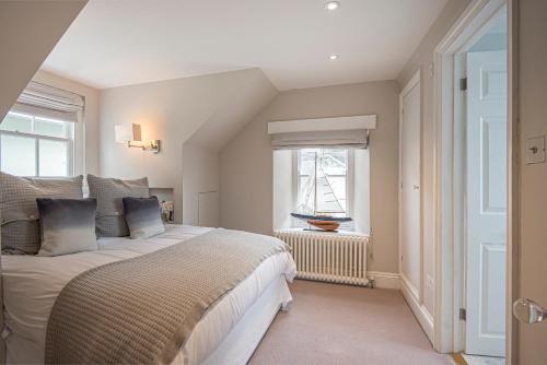 ein Schlafzimmer mit großem Bett und Fenster in der Unterkunft Pitchford House (7 Bedrooms), Salcombe. in Salcombe