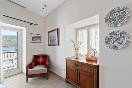 um quarto com uma secretária, uma cadeira e uma janela em Seafront, Luxury 2-BDR Townhouse em Andros