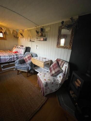 a room with a bed and a table in a tent at Oakley View Shepherds Hut with hot tub in Whitby