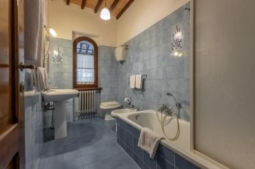 a bathroom with a tub and a toilet and a sink at Villa Palazzo Bello con piscina e AC - Cetona in Cetona