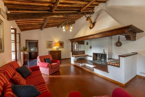 a living room with a red couch and a fireplace at Villa Palazzo Bello con piscina e AC - Cetona in Cetona