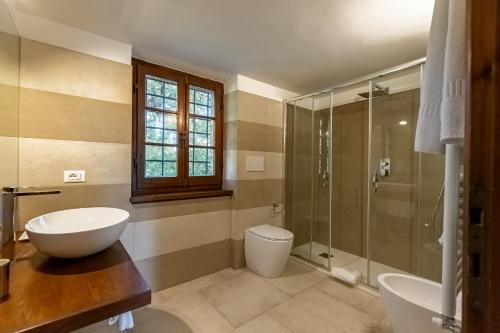 a bathroom with a sink and a toilet and a shower at Villa Palazzo Bello con piscina e AC - Cetona in Cetona