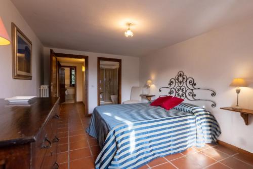 a bedroom with a bed with a blue and white striped blanket at Villa Palazzo Bello con piscina e AC - Cetona in Cetona