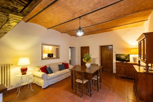 a living room with a couch and a table at Villa Palazzo Bello con piscina e AC - Cetona in Cetona