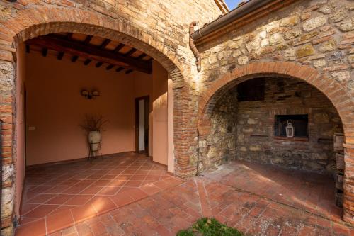an external courtyard of a house with two arches at Villa Palazzo Bello con piscina e AC - Cetona in Cetona