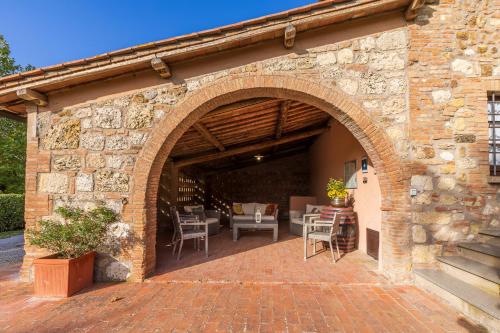 an archway in a brick building with tables and chairs at Villa Palazzo Bello con piscina e AC - Cetona in Cetona
