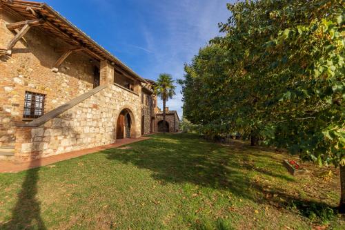 an old stone building with a tree in the yard at Villa Palazzo Bello con piscina e AC - Cetona in Cetona