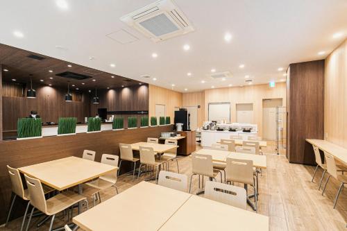 a restaurant with tables and chairs and a bar at Smile Hotel Hakataekimae in Fukuoka