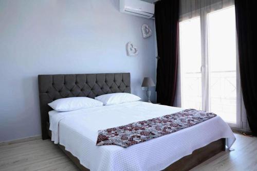 um quarto com uma cama grande e um cobertor branco em Damias rental rooms em Tessalónica