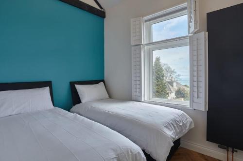 two beds in a room with a window at Modern house in Carbis Bay in Carbis Bay