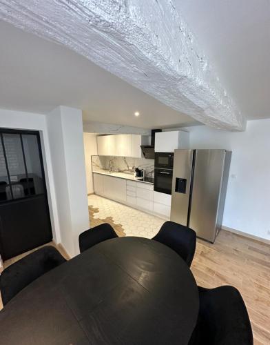 une salle à manger avec une table et une cuisine dans l'établissement Elégance spacieuse, à Saint-Georges-sur-Baulche