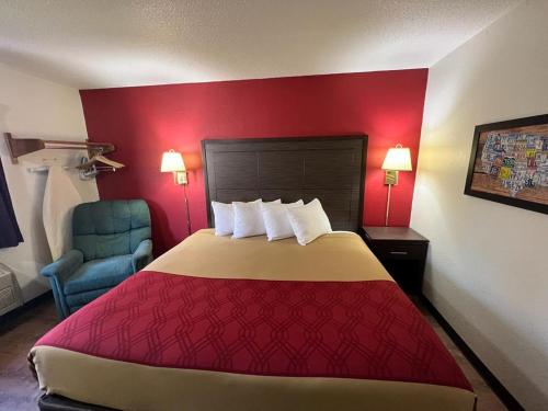Habitación de hotel con cama y silla azul en Econo Lodge Oacoma en Oacoma