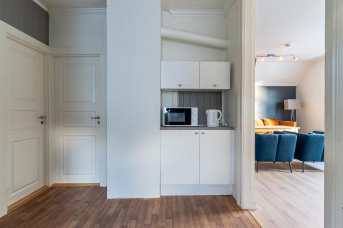 a kitchen with white cabinets and a living room at Villa Svolvær in Svolvær