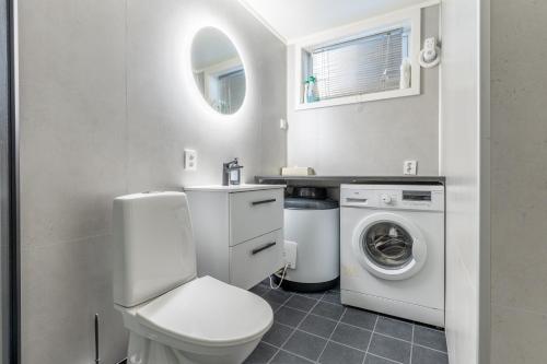 a bathroom with a toilet and a washer and dryer at Villa Svolvær in Svolvær