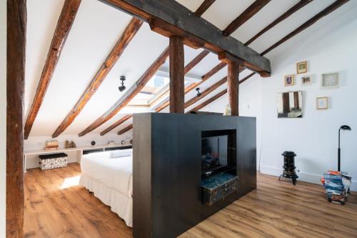 1 dormitorio con chimenea en un loft con vigas de madera en apartamento en alonso martinez, en Madrid