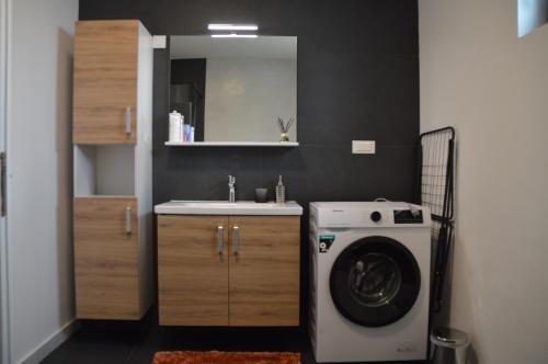 a bathroom with a washing machine and a sink at UrbanApartment5 in Čakovec