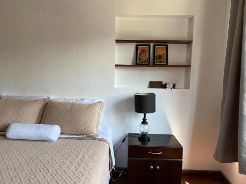 a bedroom with a bed and a lamp on a night stand at Casa Stella Centro Histórico in Guatemala