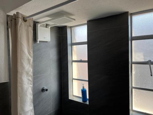 a bathroom with a shower with a blue bottle on a window at Casa Stella Centro Histórico in Guatemala