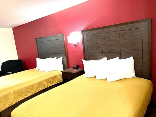 two beds in a hotel room with red walls at Econo Lodge Oacoma - Chamberlain West in Oacoma