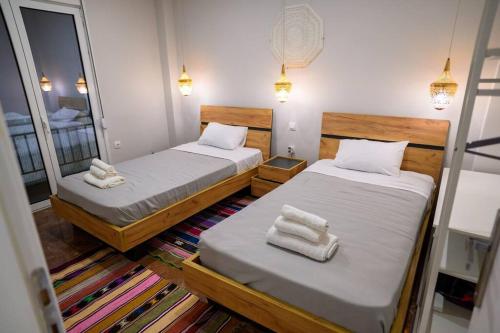 duas camas num pequeno quarto com toalhas em Boho 2 bdr luxury meets the East em Atenas