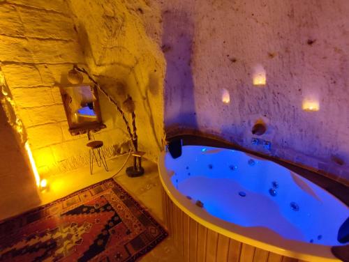 ein großes Bad mit einer Badewanne in einer Höhle in der Unterkunft Euphoria Cave House in Nar
