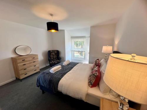 a bedroom with a bed and a dresser and a window at Lime Tree in blue Duplex Serviced Apartment in Cambridge