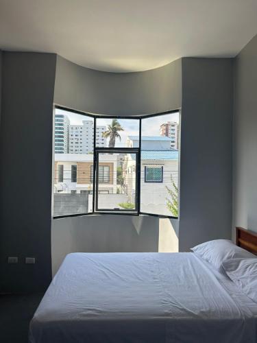 a bedroom with a bed and a large window at Hotel Ipanema Beach by Majestic in Salinas