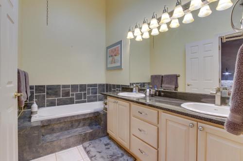 a bathroom with two sinks and a bath tub and a tubermott at Inviting Great Falls Home with Wraparound Deck! in Great Falls