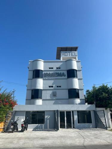 薩利納斯的住宿－Hotel Ipanema Beach by Majestic，停在前面的一座带摩托车的建筑