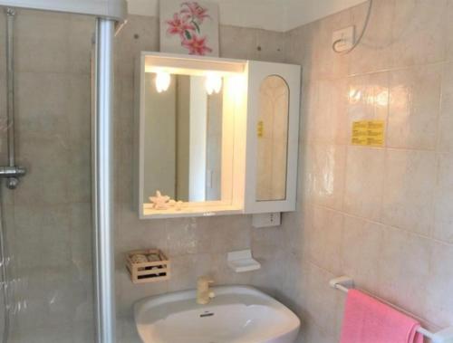 a bathroom with a sink and a mirror and a shower at Cozy oasis for families-Beahost in Bibione