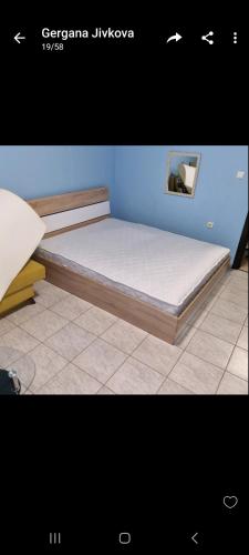 a bed in a room with a blue wall at Студия първа линия Черноморец in Chernomorets