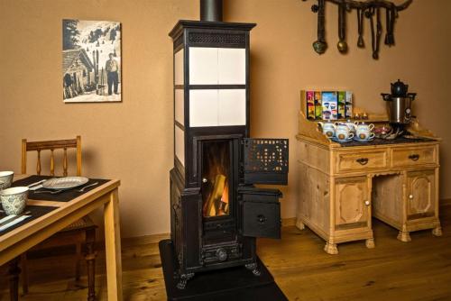 a woodburning stove in a room with a table at Hotel Chesa Staila in La Punt-Chamues-ch
