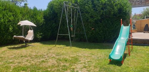 a playground with a slide and an umbrella at Le studio du Parc au cœur de Chaumont in Chaumont