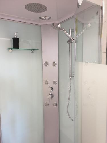 a bathroom with a shower with a shower head at Le studio du Parc au cœur de Chaumont in Chaumont