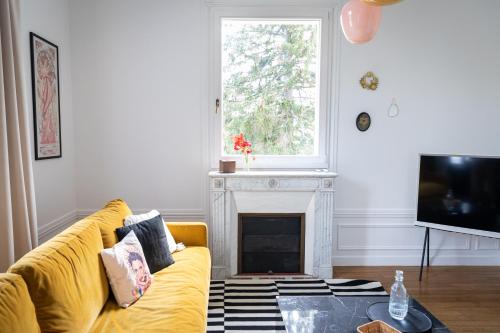 sala de estar con sofá amarillo y chimenea en LA GRANDE MAISON LGM, en Lesches