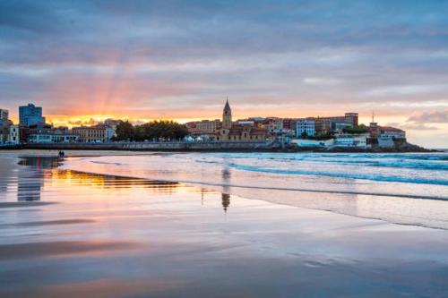 a view of a beach with a city in the background at CENTRO GIJON CABRALES 31 in Gijón