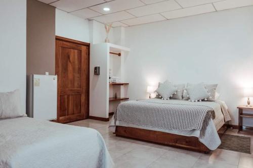 um quarto com 2 camas e um frigorífico em HOTEL AYRE By Baltra em Puerto Ayora