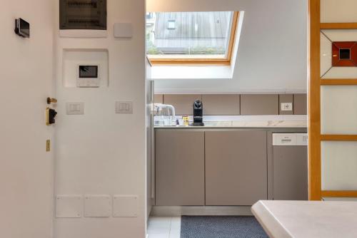 a kitchen with white cabinets and a window at Meraki Apartment in Milan