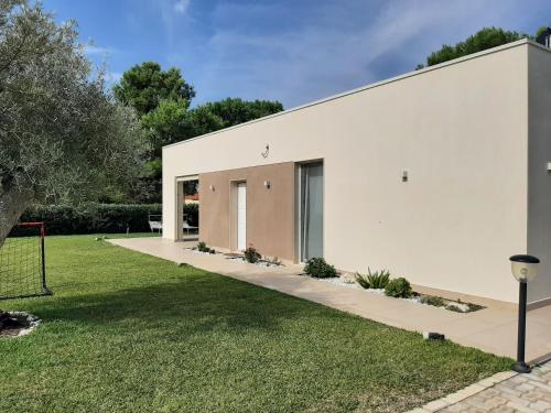 a white house with a grass yard at Il Giardino dei Coralli in Plemmirio