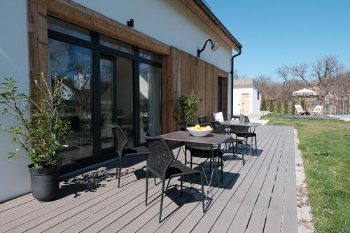 una terrazza in legno con tavolo e sedie. di Szarata204 