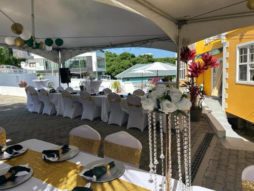 a group of tables and chairs under a tent at Faith's Villa Tobago in Diamond